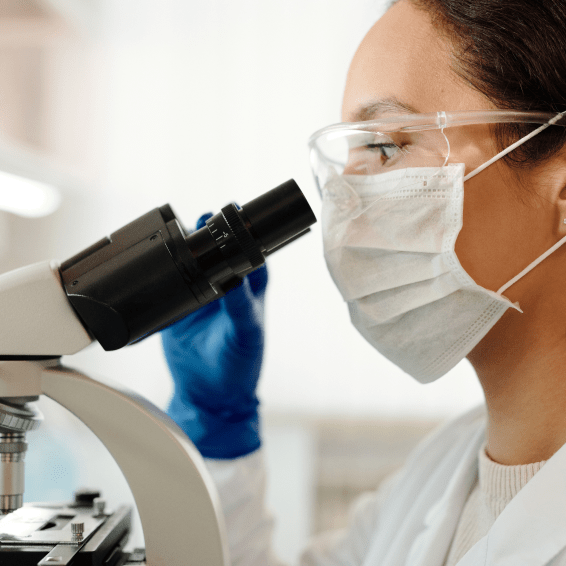 woman looking into a microscope