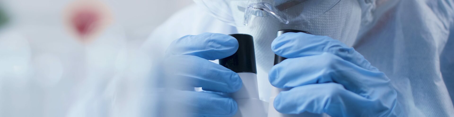doctor looking into medical microscope
